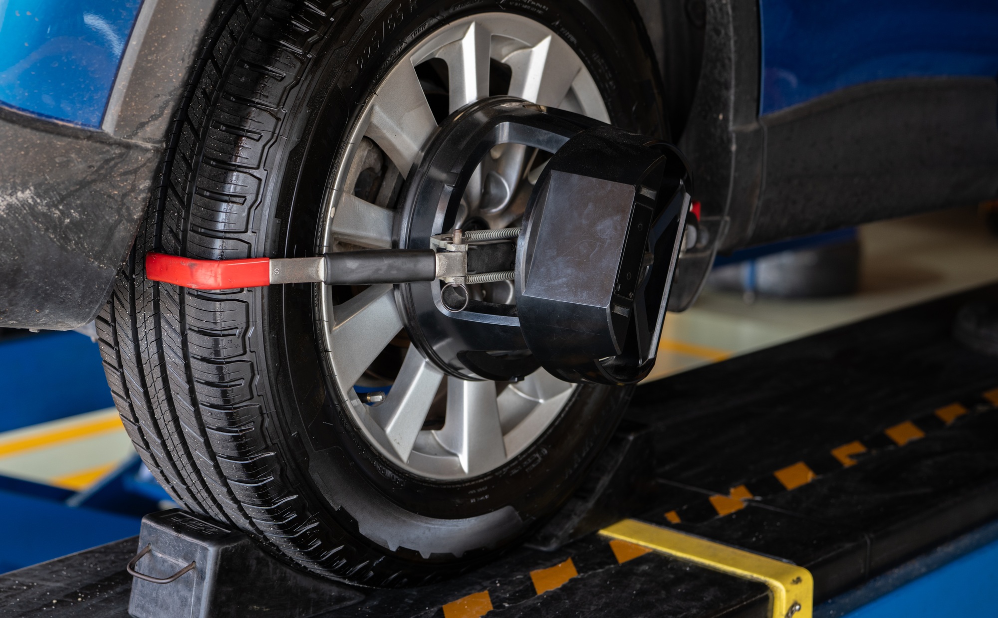 Wheel alignment equipment grip the tire of car wheel in car repair shop Auto wheel alignment